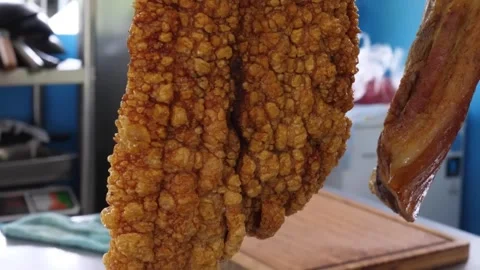 Slow-motion closeup of freshly cooked crispy pork belly with golden crackling sk Stock Footage 338211760