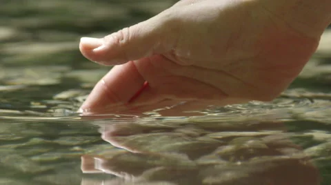 SLOW MOTION CLOSEUP: Hand grabbing and lifting crystal clear water Stock Footage 55445987