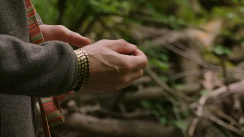 Slow motion closeup insert: A man's hands toss pebbles into a river in the woods Video stock 108806057