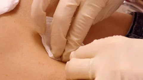 Slow motion closeup master wipes skin around belly ring Stock Footage 101650815