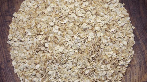 Slow motion closeup oat flakes falling into bowl Stock Footage 97936606