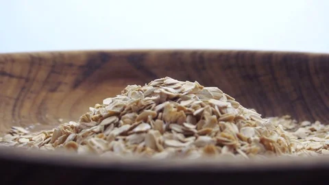 Slow motion closeup oat flakes falling into bowl Stock Footage 97936717