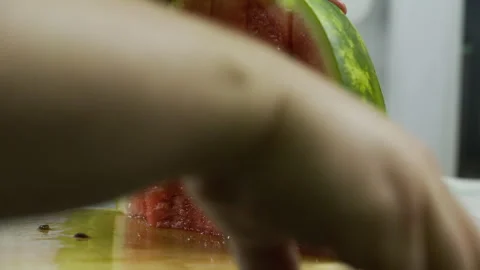 Slow motion closeup up of person breaking and slicing watermelon apart on Stock Footage 341257342