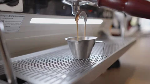 Slow motion closeup of professional espresso machine pouring hot double shot Stock Footage 328984122