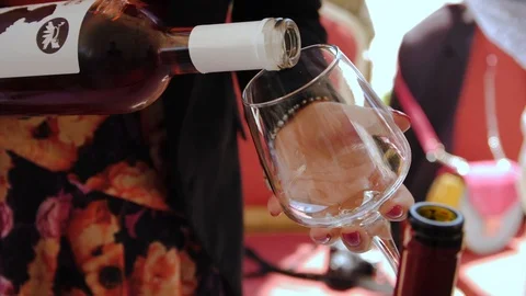 Slow motion closeup of rose wine pouring into crystal glass Stock Footage 119391992