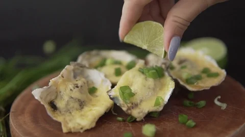 Slow motion closeup serving open oysters with cheese, green onion and lime juice Stock Footage 88720500