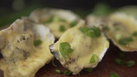 Slow motion closeup serving open oysters with cheese, green onion and lime juice 動画素材 91200809