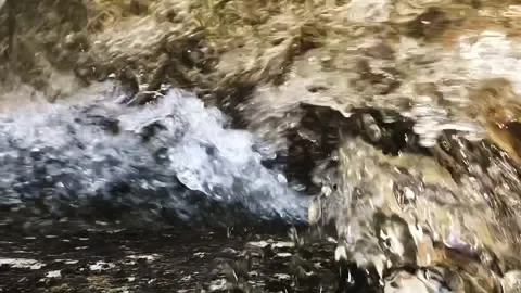 Slow-motion closeup shot from above of a clear water stream in slight downfall Stock Footage 248073475
