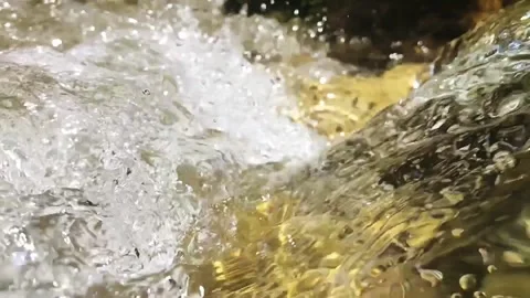 Slow-motion closeup shot of a clear water stream in slight downfall into a pool Stock Footage 248357420
