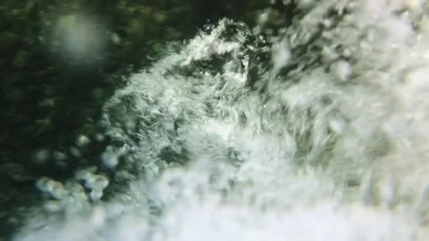 Slow-motion closeup shot of a clear water stream in slight downfall into a pool Stock Footage 248379994