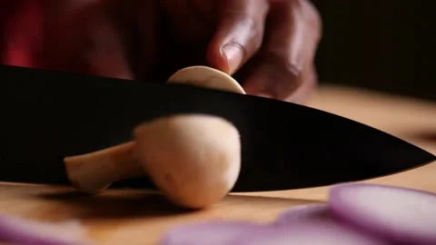 Slow motion closeup sliding or truck shot of a mushroom being chopped Stock Footage 136653317