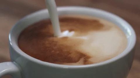 Slow motion closeup steamed milk pour into cappuccino Stock Footage