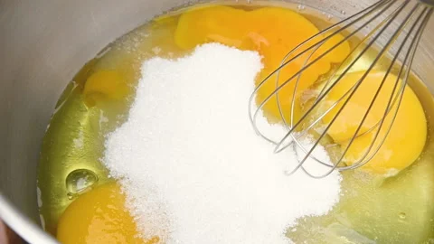 A slow-motion closeup video of a pastry chef whisking eggs Video stock 154011689