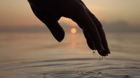 SLOW MOTION CLOSEUP: Water drops falling off a wet hand Stock Footage