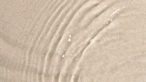 Slow motion closeup water surface texture splash and ripples on sand background Video stock 166132829