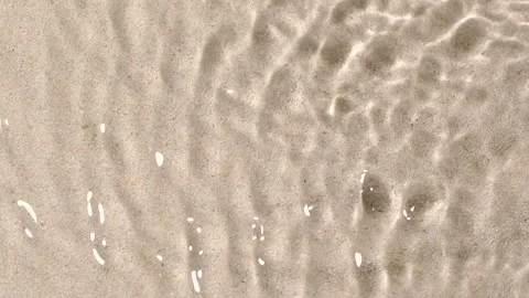 Slow motion closeup water surface texture splash and ripples on sand background Stock Footage 168341441