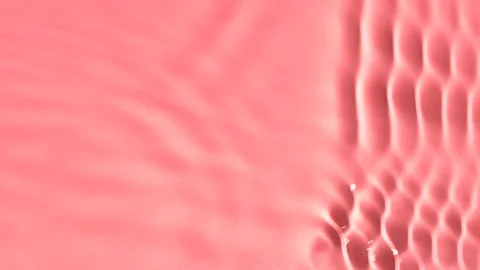 Slow motion closeup water surface texture splash and ripples on pink background Stock Footage 170171700