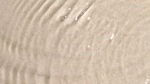 Slow motion closeup water surface texture splash and ripples on sand background Video stock 193915807