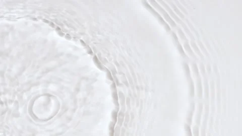 Slow motion closeup water surface texture splash and ripples on white background Stockbeeldmateriaal 198120833