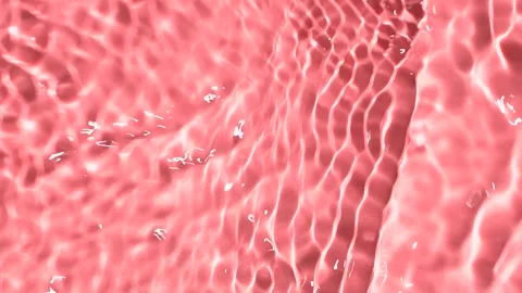 Slow motion closeup water surface texture splash and ripples on pink background Stock Footage 202239782