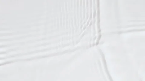Slow motion closeup water surface texture splash and ripples on white background Stock Footage 203807660