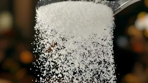 Slow motion closeup of white sugar pouring from a metal spoon Stock Footage 332870789