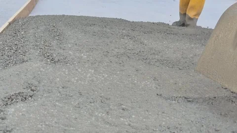 Slow motion closeup of workers pouring concrete with shovel Stock Footage 337847578