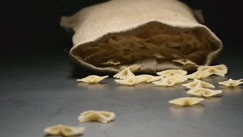 SLOW MOTION: Cloth bag falls and pasta (farfalle) fall out of him Video stock 72495908
