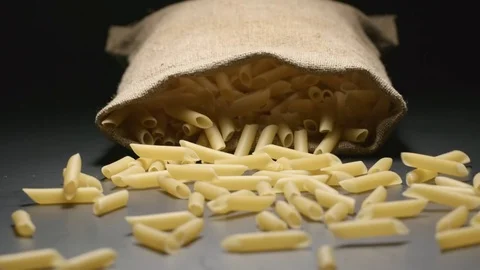 SLOW MOTION: Cloth bag falls and pasta (penne rigate) fall out of him Stock Footage 72496049