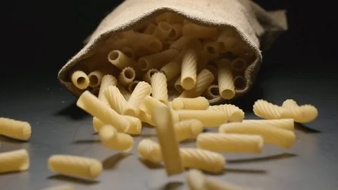 SLOW MOTION: Cloth bag falls and pasta (tortiglioni) fall out of him Video stock 72496083
