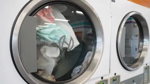 Slow motion of clothes being dried in the dryers at a local laundromat Stock Footage 248859201