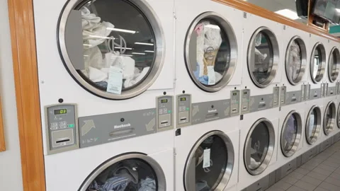 Slow motion of clothes being dried in the dryers at a local laundromat Stock Footage 248859506