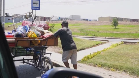 Slow motion of a clothes man pushing a cart full of things in the street Stock Footage 150917476