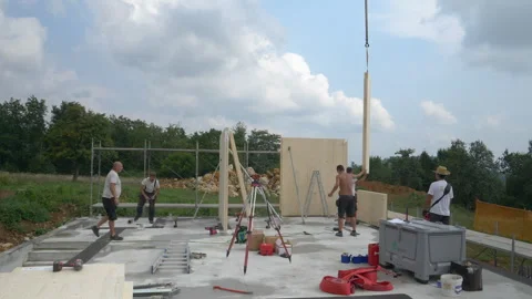 SLOW MOTION: CLT wall panels are being installed on a concrete foundation. Stock Footage 307880373