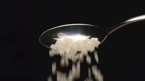 SLOW MOTION: Coarse salt falls from a spoon Видео 72736083