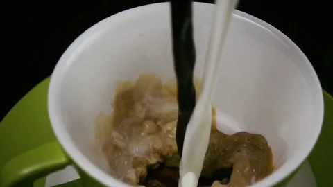 Slow motion. Coffee and milk are poured into the cup at the same time Stock-Footage 75811949