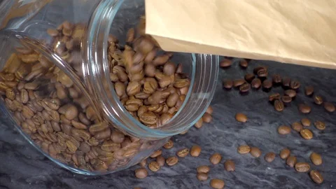 Slow Motion – Coffee beans pouring into a storage jar. Stock Footage 129188254