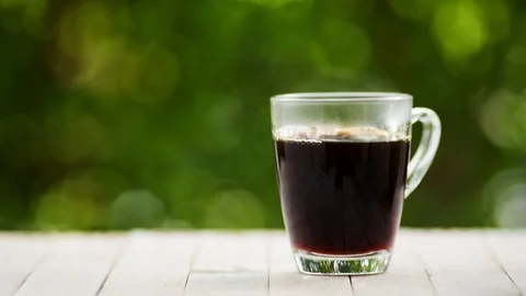 Slow motion of coffee cup in a garden Stock Footage 100451318