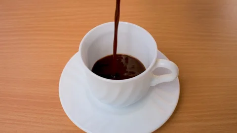 Slow motion coffee pour into a white cup. Stock Footage 128636363