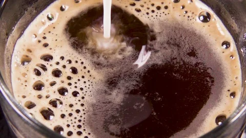 Slow motion coffee in a transparent mug to pour milk Stock-Footage 90782515