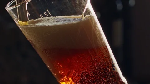 Slow motion of cold beer poured into a tall glass Stock Footage 94453450