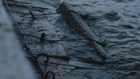 Slow motion of a cold dark sea wave beating against an ancient concrete Stock Footage 120894955