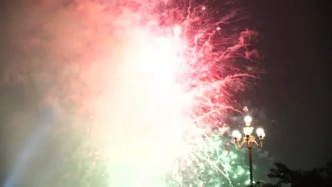 Slow Motion Colorful fireworks that explode and fill the darkness of the nig Stock Footage 204635997