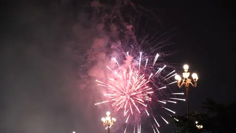Slow Motion Colorful fireworks that explode and fill the darkness of the nig Stock Footage 204711289