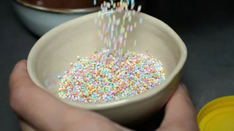 Slow Motion Colorful Sprinkles Falling into Bowl Video stock 320393531