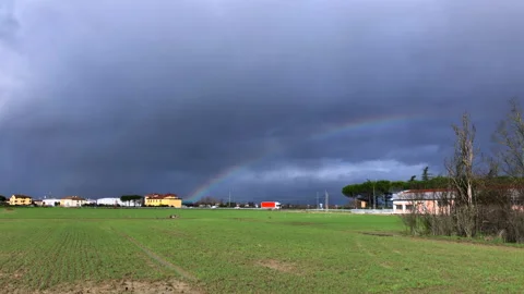 Slow motion: Colourful rainbow in the sky over a city landscape with traffic Stock Footage 148128091