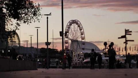 Slow motion Commuters around Sunset with Darling Harbour Ferris Wheel Stock Footage 220781629