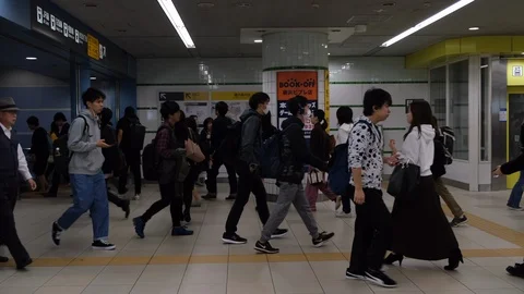 Slow motion: Commuters walking through train station during rush hour in Tokyo. Stock Footage 123816138