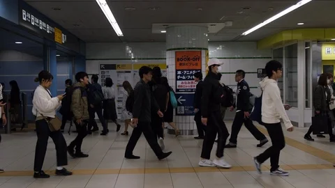 Slow motion: Commuters walking through train station during rush hour in Tokyo. Stock Footage 123816768