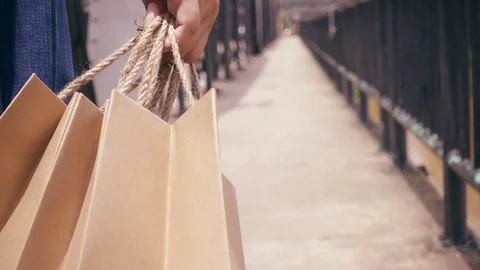 Slow motion of confident female with shopping bags walking in a city. Steadicam Stock Footage